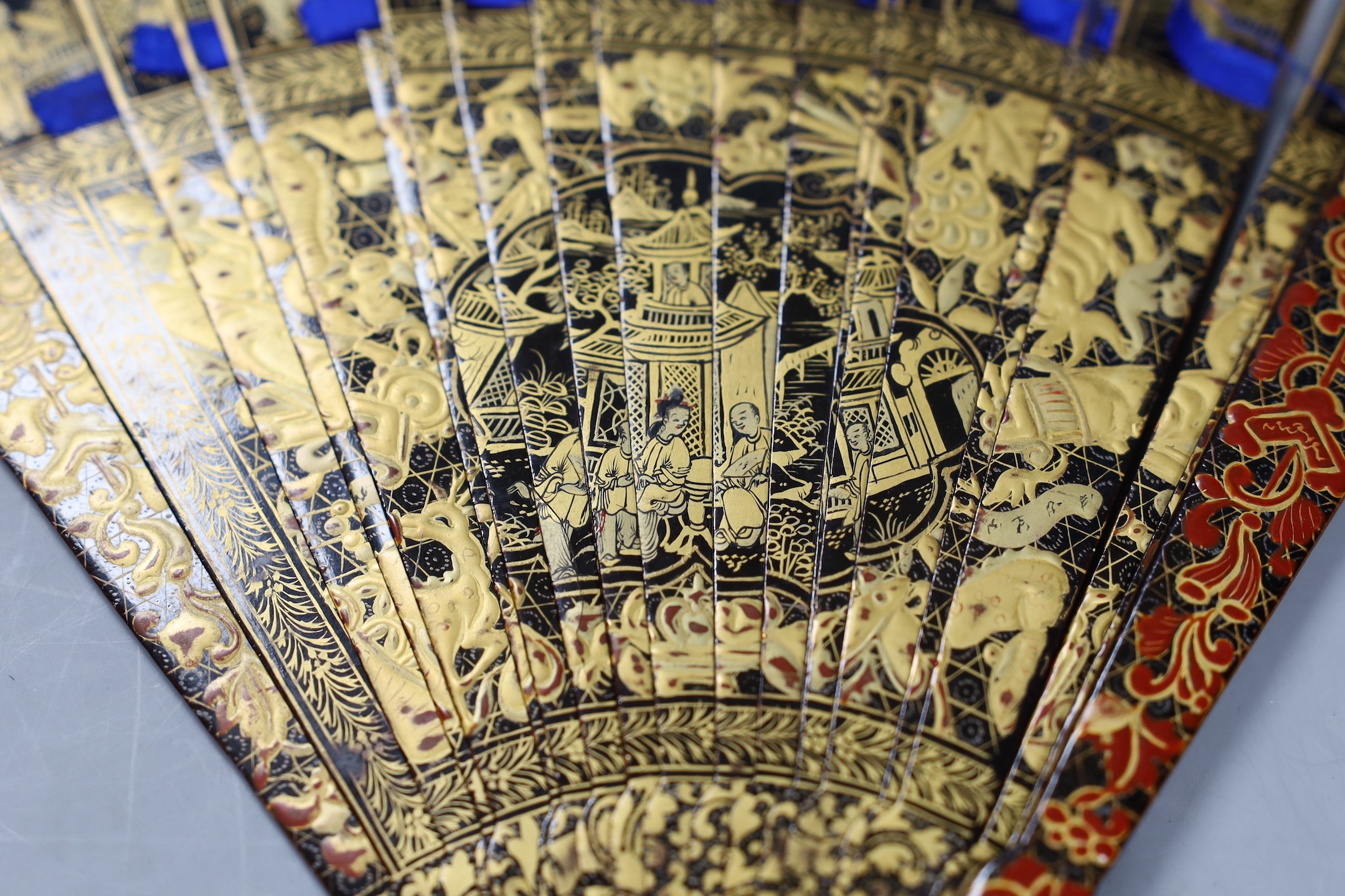A Chinese gilt-decorated lacquer fan in a brocade covered case, 19th century